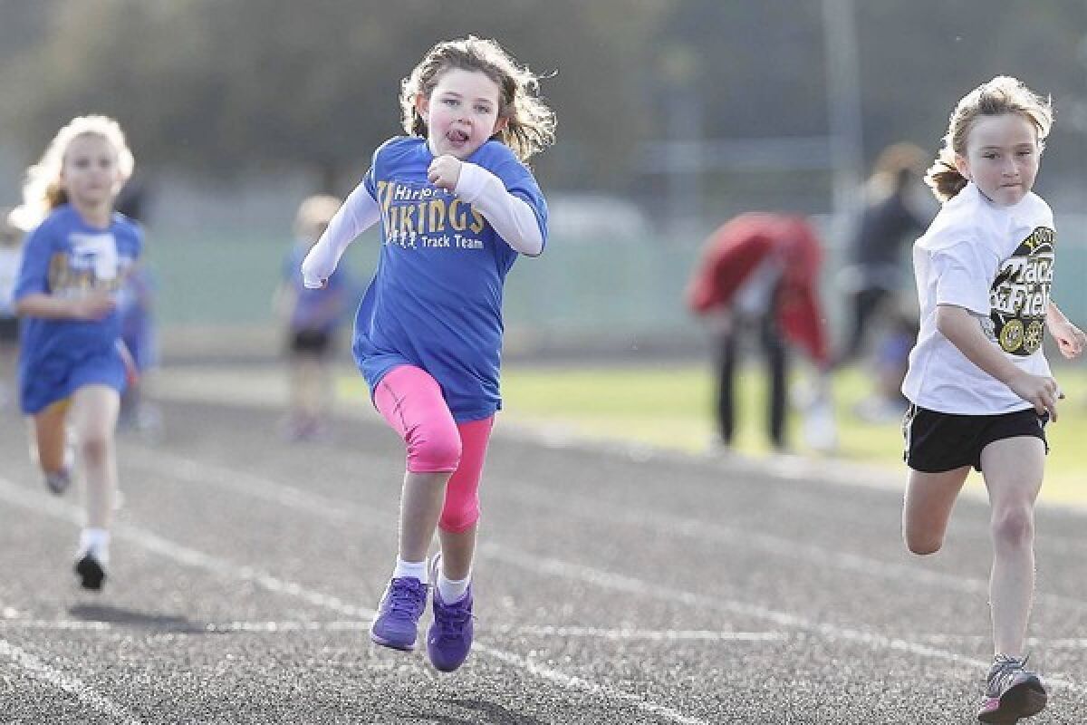 Payton Chester, center, then 6 years old, sprints to the finish line in the 50-meter dash during the Newport-Balboa Rotary Club's Youth Track Meet of Champions in 2013.