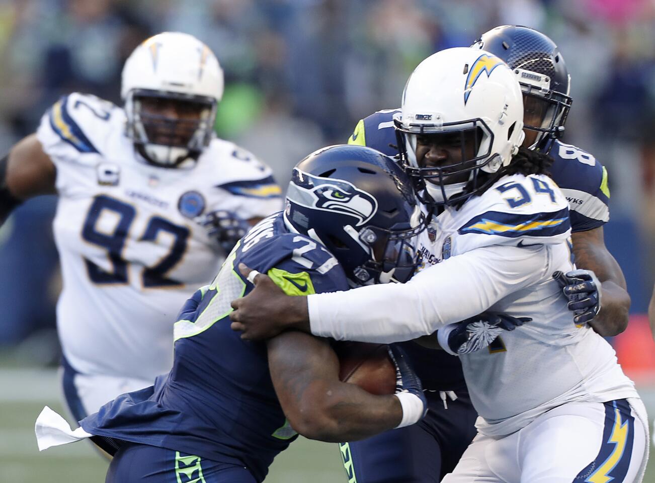 Chargers defensive end Melvin Ingram III wraps up Seattle Seahawks running back Mike Davis in the third quarter Sunday at Century Link Field in Seattle.