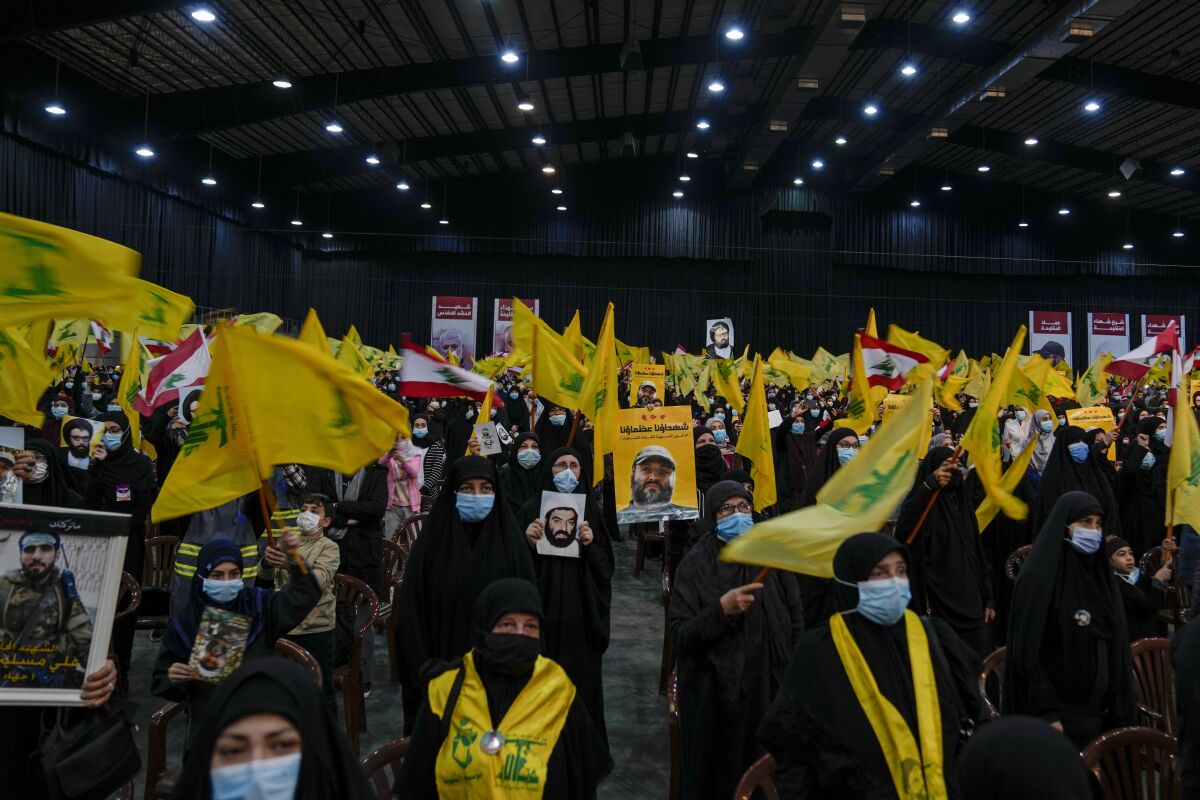 Hezbollah supporters sing the Lebanese and Hezbollah anthems during an annual ceremony commemorating the killing of some of the Iran-backed group's top political and military leaders, in the southern suburb of Beirut, Lebanon, Wednesday, Feb. 16, 2022. Nasrallah revealed Wednesday in a televised speech that his militant faction has been manufacturing military drones in Lebanon and has the technology to turn thousands of missiles in their possession into precision-guided munitions. (AP Photo/Hassan Ammar)