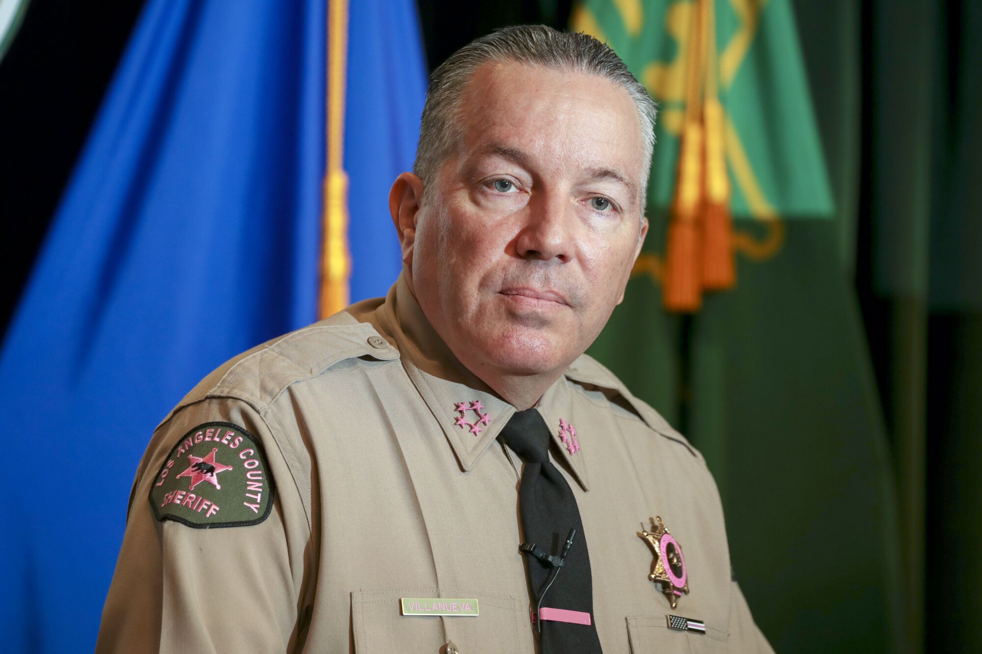 L.A. County Sheriff Alex Villanueva with flags in background