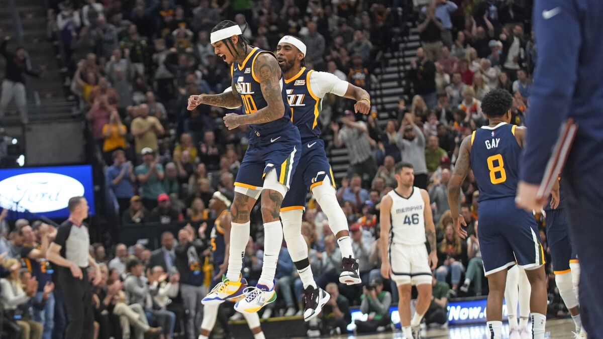 Utah Jazz's Jordan Clarkson, left, and Mike Conley, right, celebrate during the second half of the team's NBA basketball game against the Memphis Grizzlies on Tuesday, April 5, 2022, in Salt Lake City. (AP Photo/Rick Bowmer)