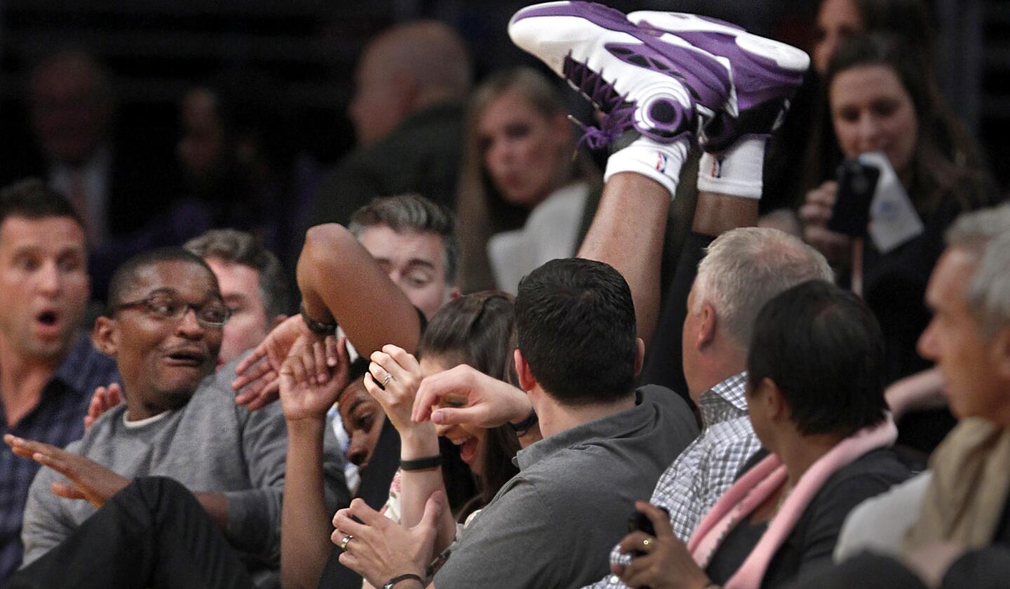 Kings forward Carl Landry lands upside down as he chases a loose ball into the courtside seats in the second half Wednesday night at Staples Center.