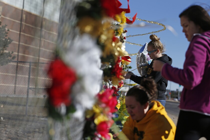 Students leave flowers and other items at a makeshift tribute site the week after a shooting attack at Arapahoe High School in Centennial, Colo.