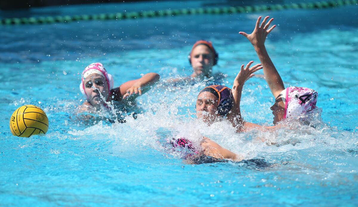 Destiny Hernandez of the Huntington Beach 18-and-under Orange team, in dark cap, is surrounded by SET's Tea Poljak, left, and Honnie Vandeweghe-O'Shea (4) in the USA Water Polo Junior Olympics match on Friday at Tustin High.