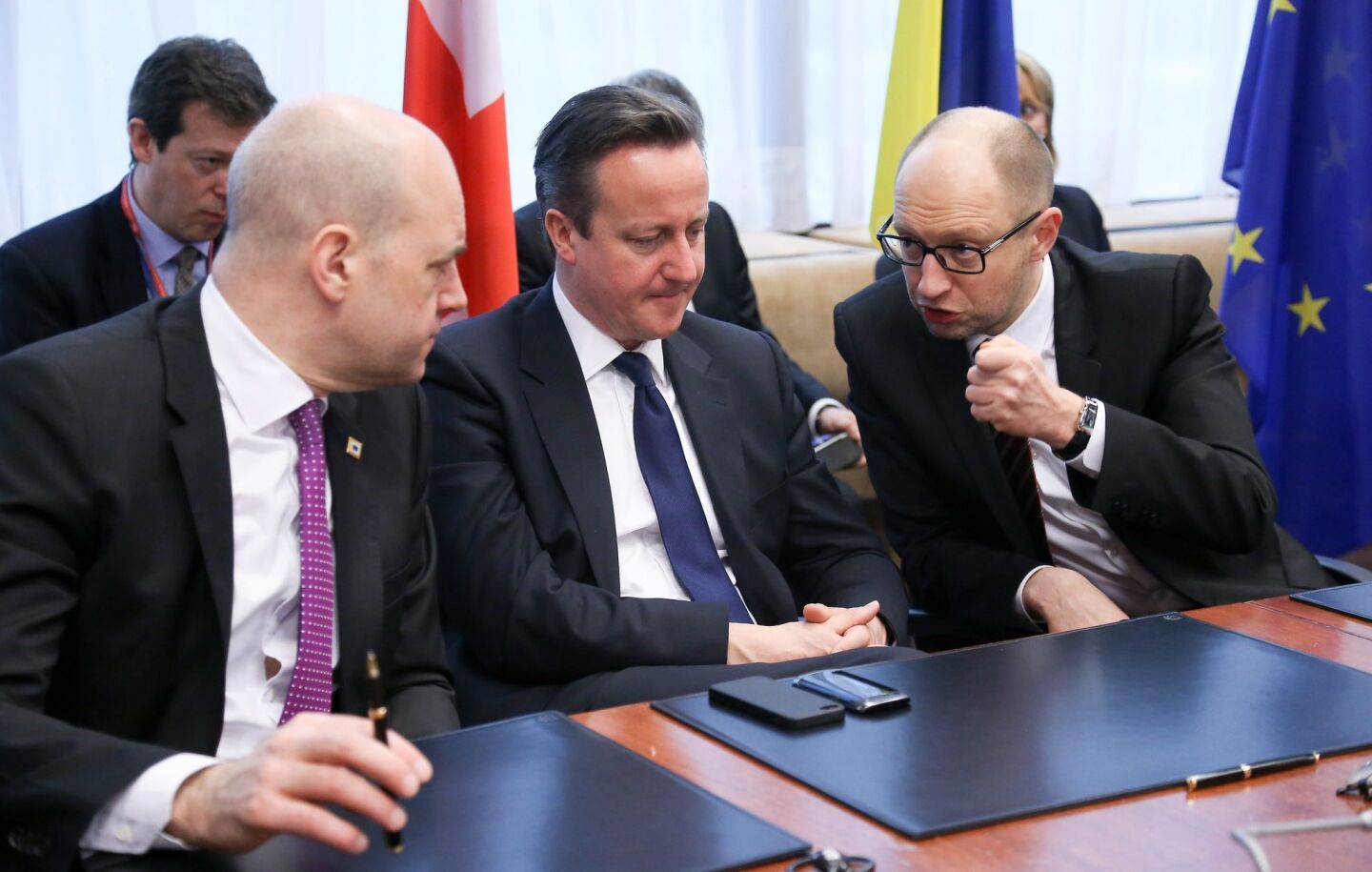 Ukrainian Prime Minister Arseny Yatsenyuk, right, chats with British Prime Minister David Cameron, middle, and Swedish Prime Minister Fredrik Reinfeldt during a signing ceremony at a summit in Brussels.