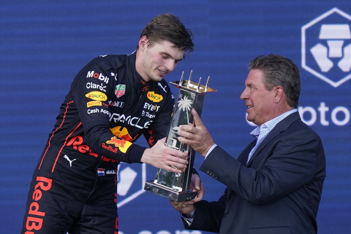 Red Bull driver Max Verstappen of the Netherlands receives the winner's trophy from former Miami Dolphins quarterback Dan Marino at the Formula One Miami Grand Prix auto race at the Miami International Autodrome, Sunday, May 8, 2022, in Miami Gardens, Fla. (AP Photo/Lynne Sladky)