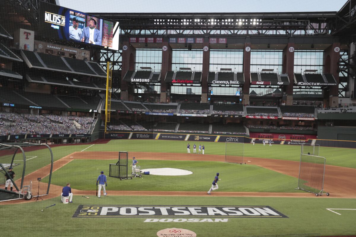 View from behind the first base-side dugout of Dodgers practicing at Globe Life Field in Arlington, Texas, on Monday.