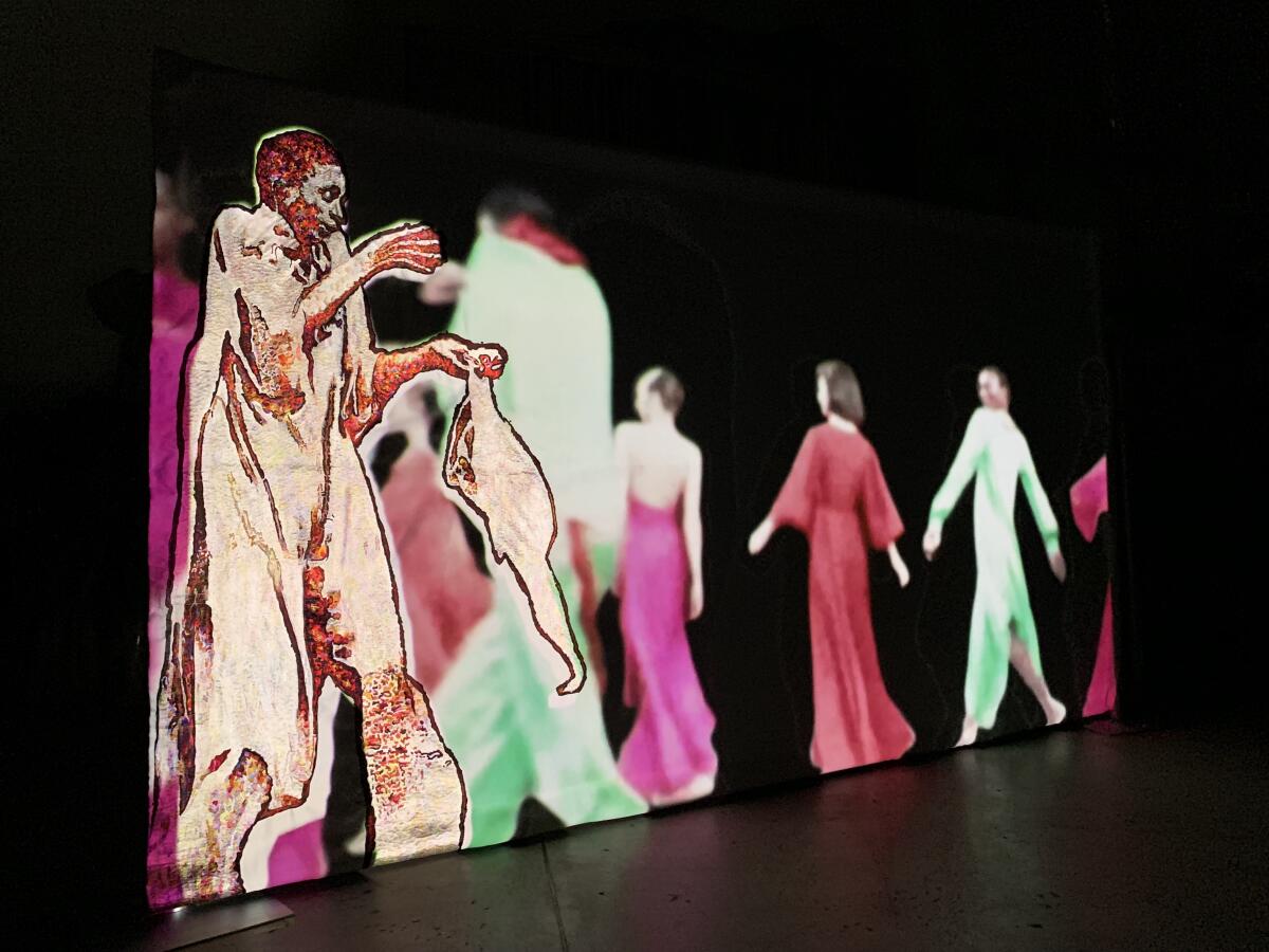 A video installation shows models in a runway show.