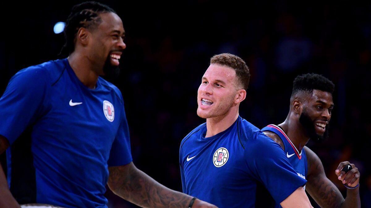 Clippers' Blake Griffin, middle, and DeAndre Jordan, left, laugh during a timeout in a 108-92 Clippers win during the Lakers' home opener at Staples Center on Thursday.