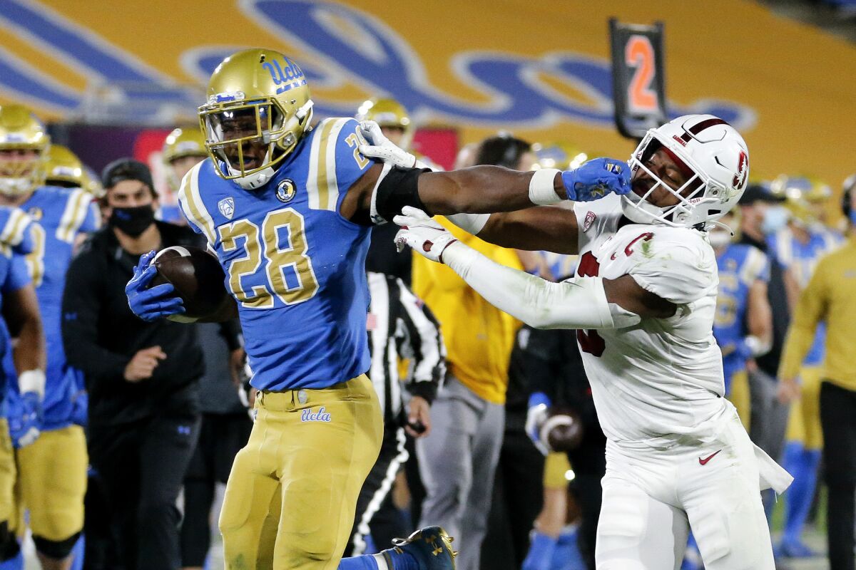 UCLA running back Brittain Brown stiff-arms Stanford safety Malik Antoine on Dec. 19.