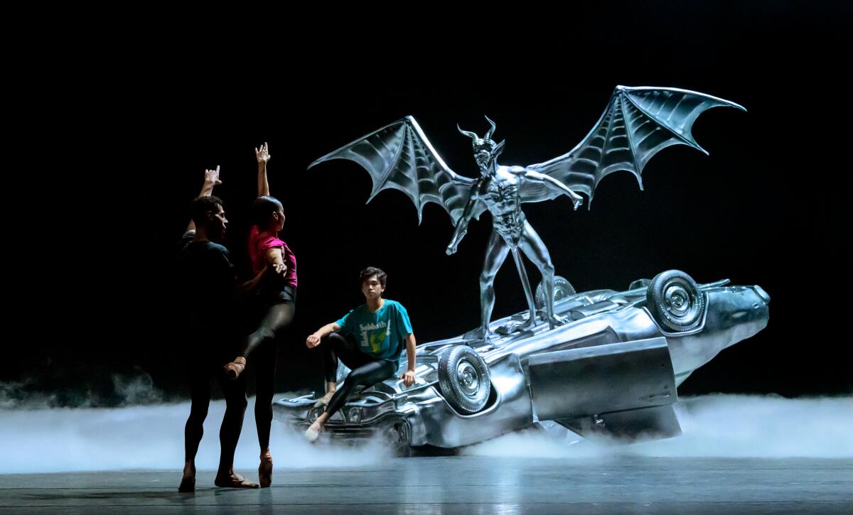 Dancers perform around an upside down car with a demon during a dress rehearsal of "Black Sabbath — The Ballet."