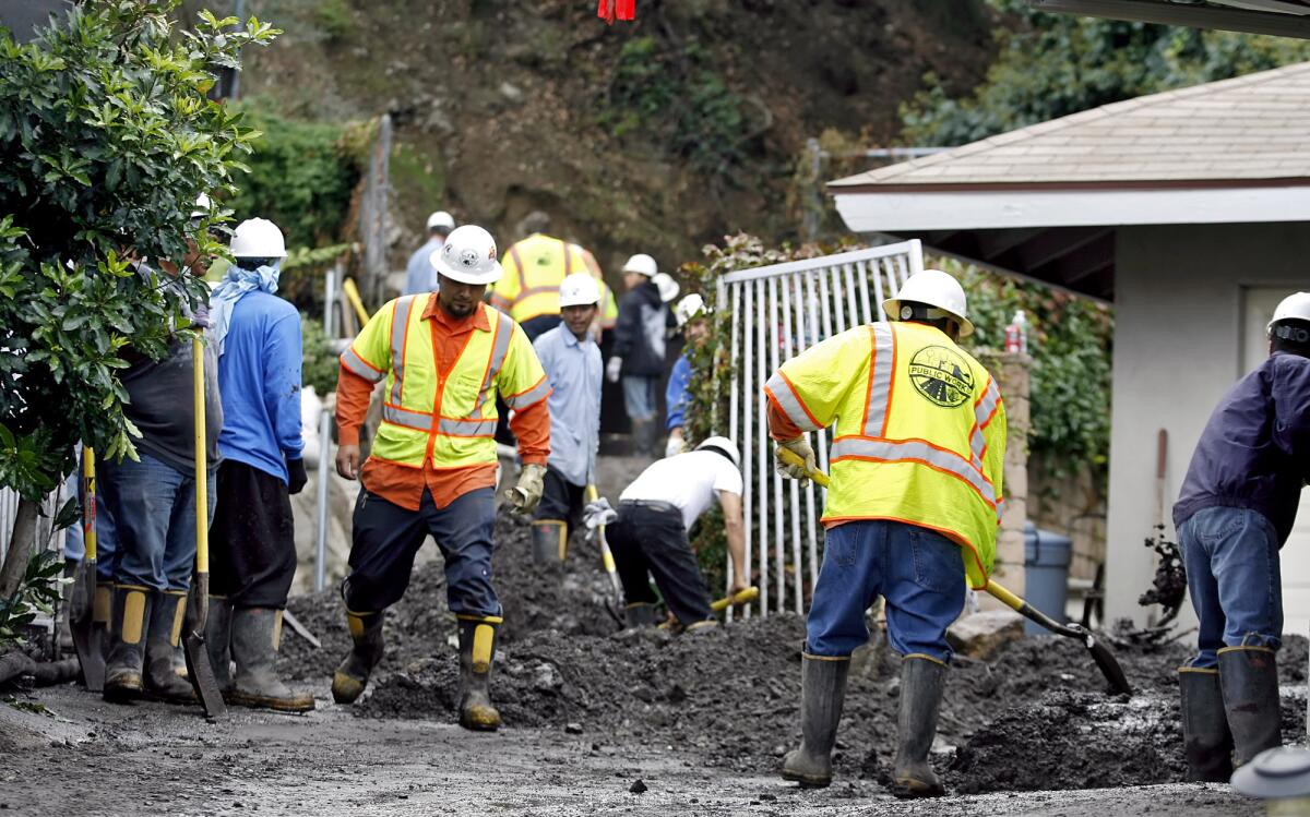 L.A. County Department of Public Works crews remove mud from a backyard on Earnslow Drive in La Cañada Flintridge on Nov. 13, 2009. A sudden storm the night before caused the damage.