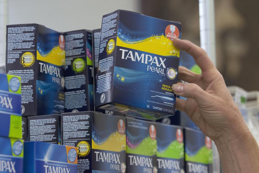 FILE - In this June 22, 2016, file photo, Tammy Compton restocks tampons at Compton's Market, in Sacramento, Calif. California public schools and colleges would have to stock their restrooms with free menstrual products under legislation sent to Gov. Gavin Newsom on Thursday, Sept. 9, 2021. The bill by Democratic Assemblywoman Cristina Garcia builds on her 2017 law requiring low-income schools in disadvantaged areas to provide students with free menstrual products. (AP Photo/Rich Pedroncelli, File)