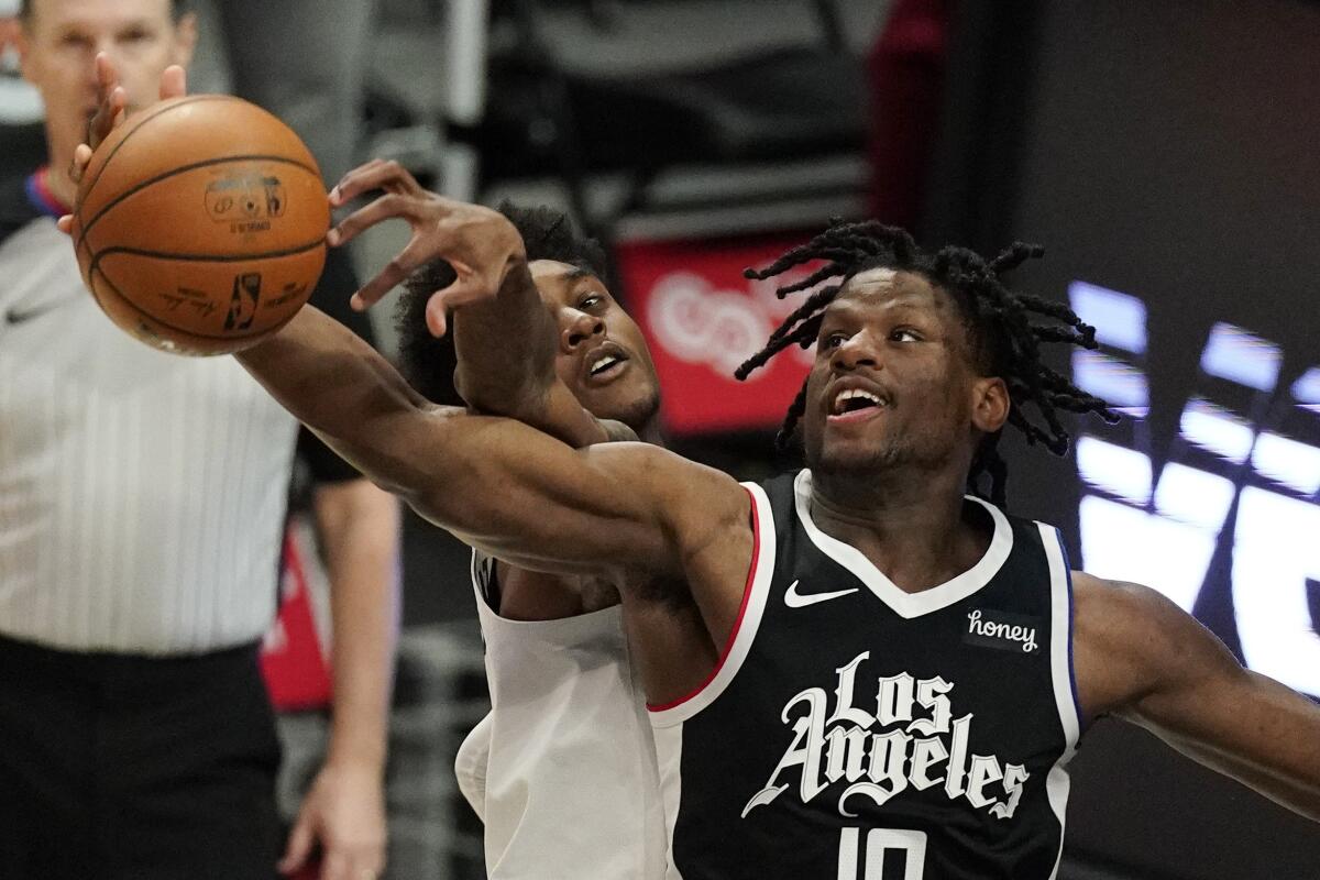 Minnesota Timberwolves forward Jaden McDaniels, left, and Clippers center Daniel Oturu battle for a rebound.