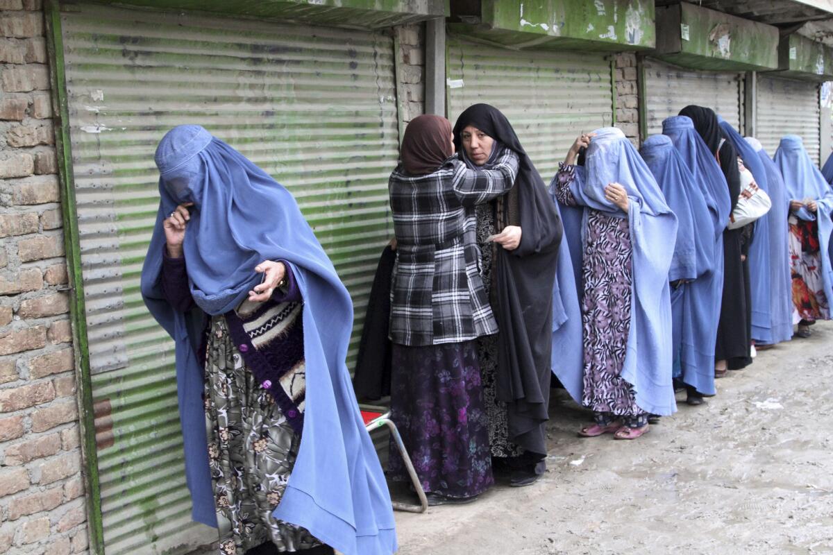 Female voters are searched by a poll worker before they enter a polling station in Kabul on Saturday.