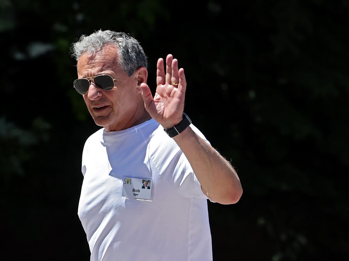 Bob Iger waves wearing sunglasses. 