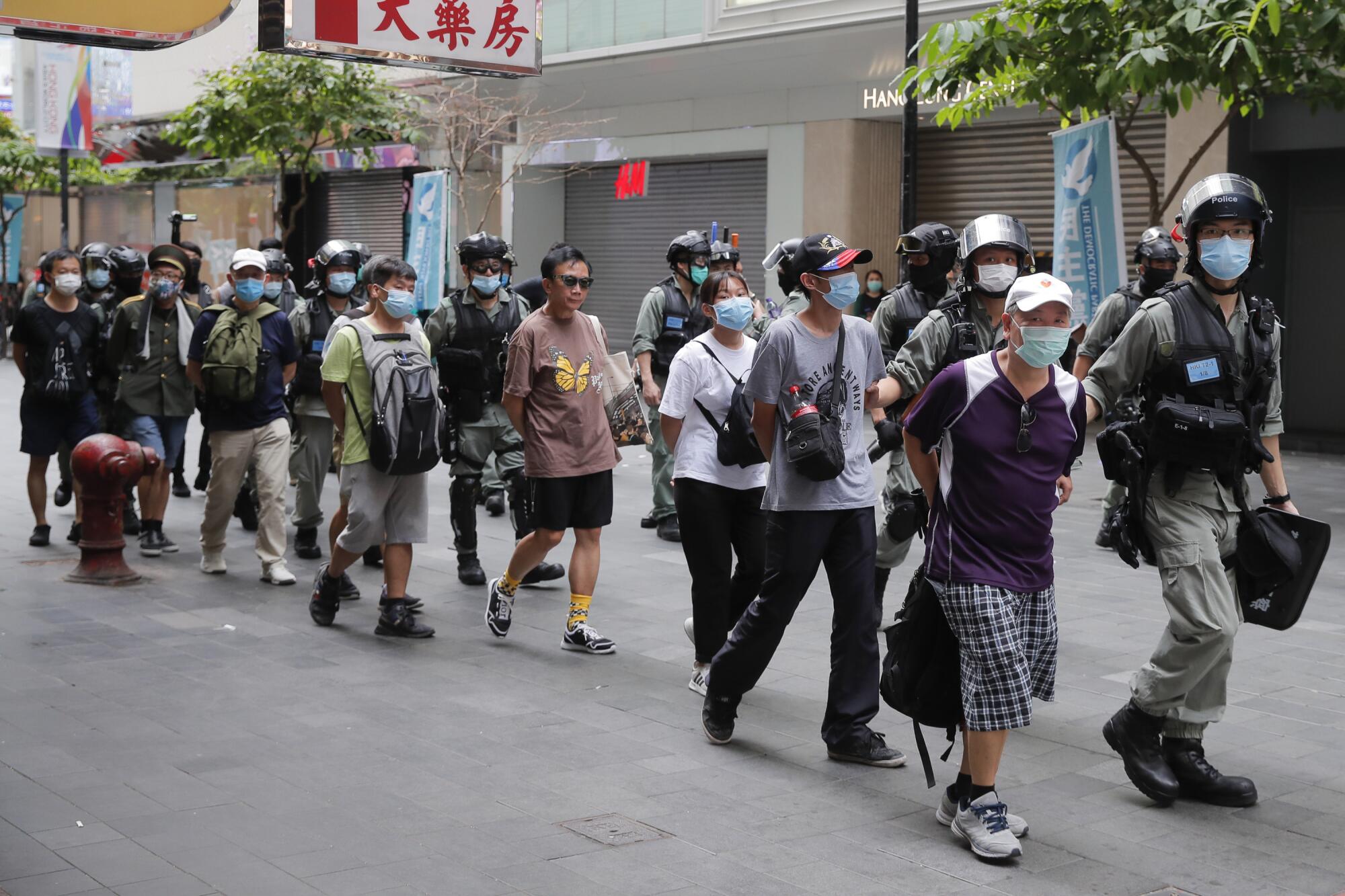 Police detain protesters after a protest in Causeway Bay before the annual handover march in Hong Kon