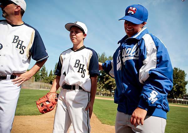 Birmingham pitcher Marti Sementelli, left, and San Marcos pitcher Ghazaleh Sailors, right, wish each other luck before their game on Saturday at Birmingham High in Lake Balboa. It is believed to be the first boys' baseball game at which girls were the starting pitchers.