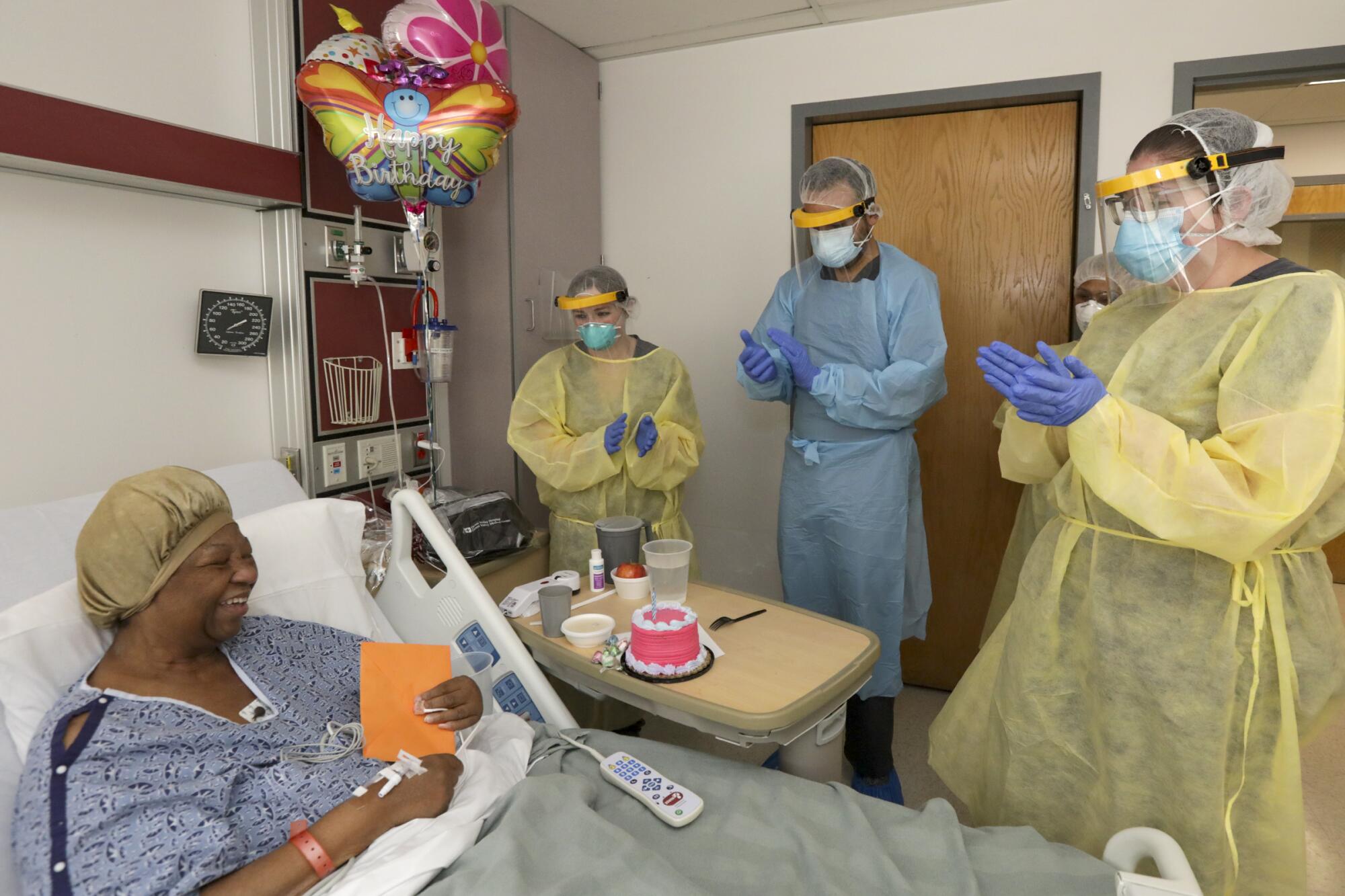 Janice Brown, left, pleasantly surprised by Dr. Imran Siddiqui, center, and nursing who brought her balloons, a card and cake to celebrate her birthday