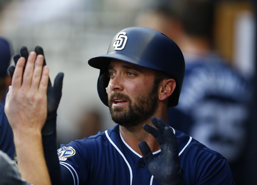 Greg Garcia of the San Diego Padres is congratulated after scoring in the first inning during the game against the Atlanta Braves at SunTrust Park on April 29, 2019 in Atlanta, Georgia.