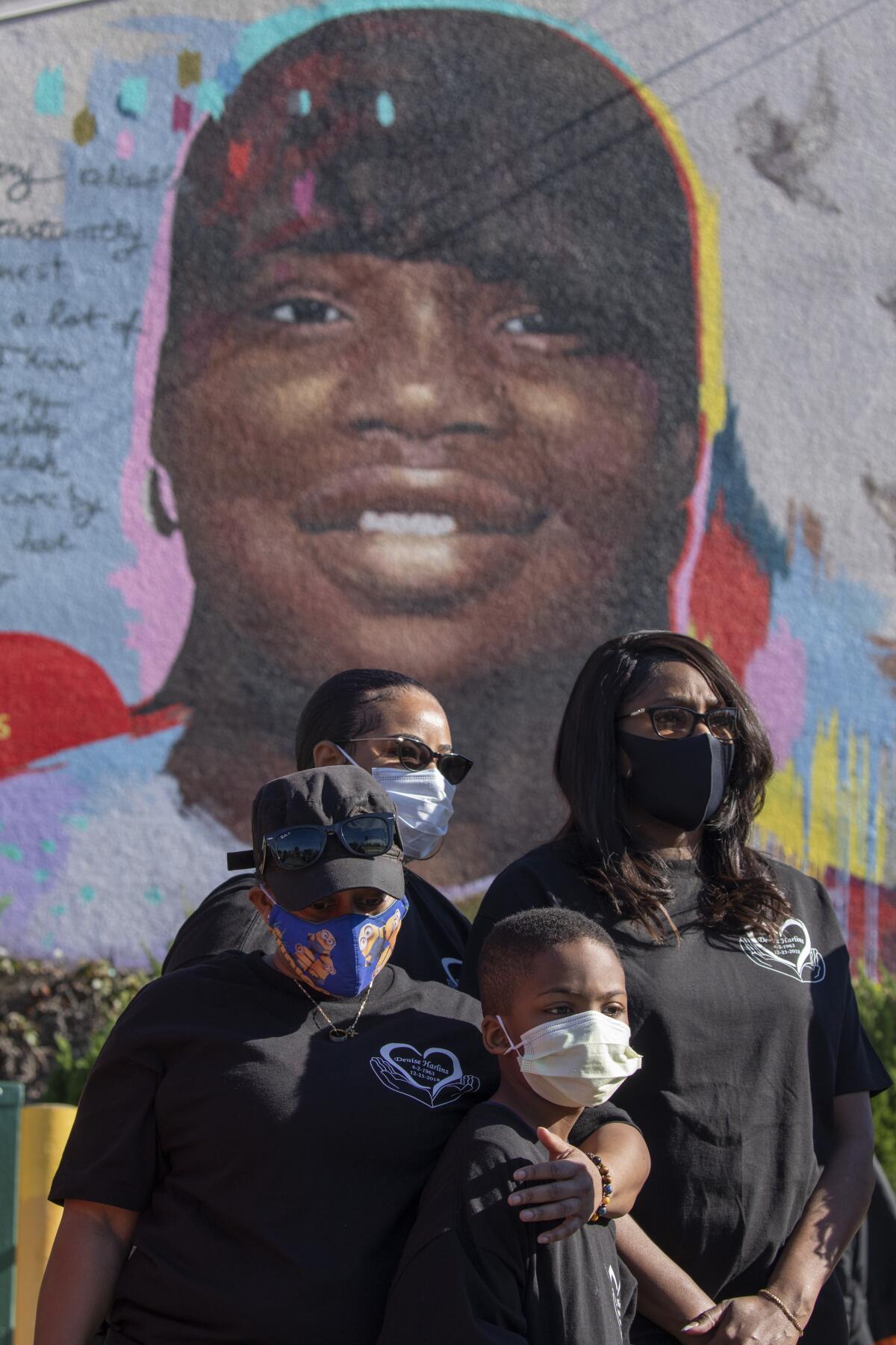 Loved ones stand before the mural of Latasha Harlins in Los Angeles.
