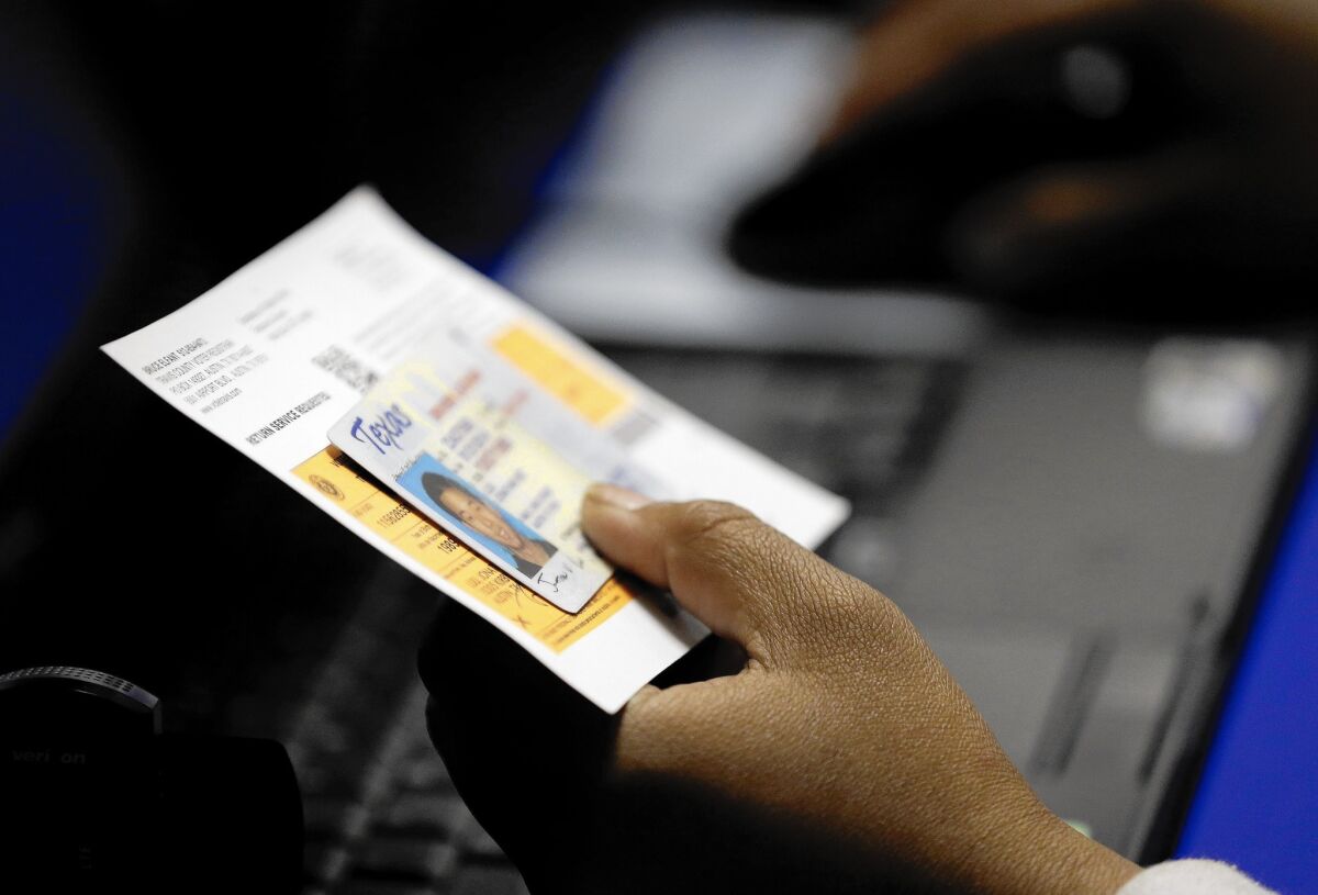 A Texas election official checks a voter's ID at an early voting location in Austin last month.