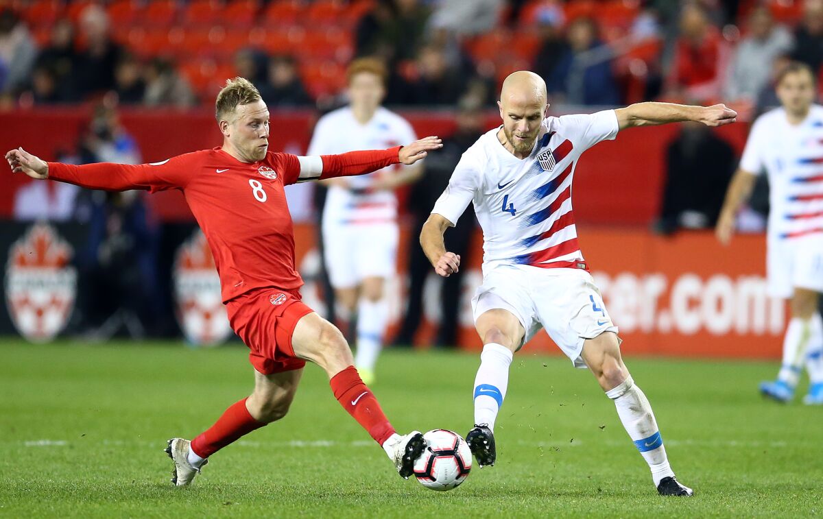 U.S. midfielder Michael Bradley (4) battles for the ball against Canada's Scott Arfield during a CONCACAF Nations League game on Oct. 15, 2019, in Toronto.