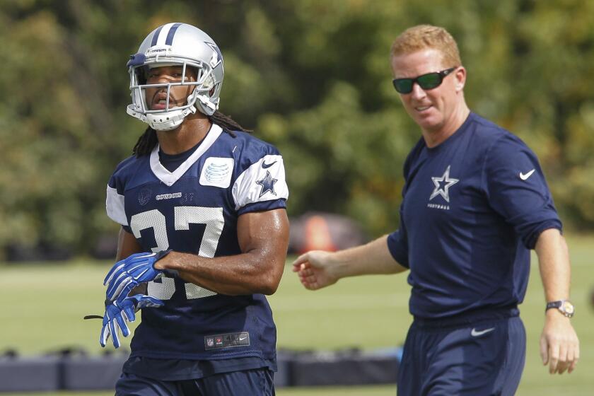 Cowboys defensive back C.J. Spillman, left, is shown with Coach Jason Garrett at a practice Thursday. Police are investigating Spillman's role in an alleged sexual assault.