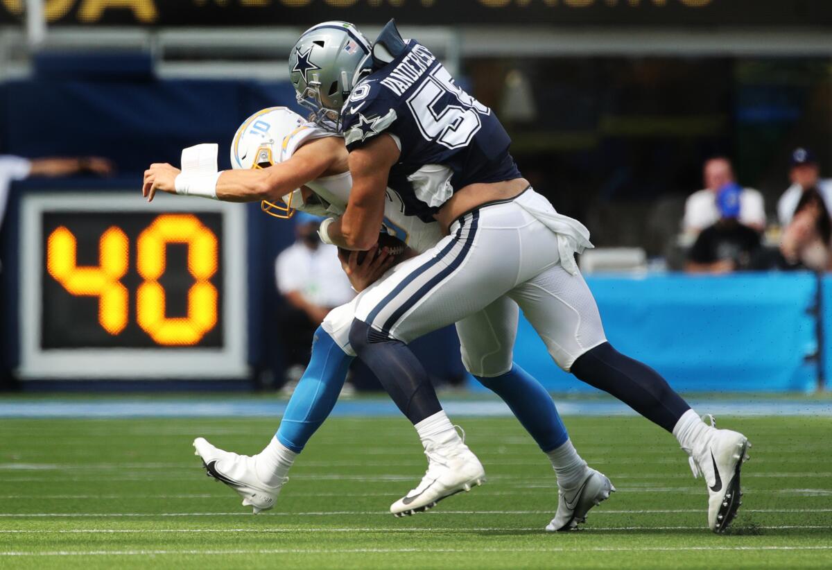 Chargers quarterback Justin Herbert (10) is sacked by Cowboys linebacker Leighton Vander Esch.