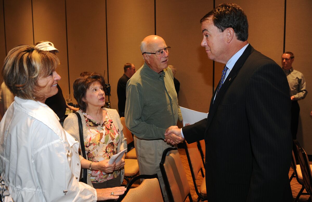 Mike Bohn, far right, shakes hands with Chuck Neinas following his resignation as Colorado athletic director in 2013.