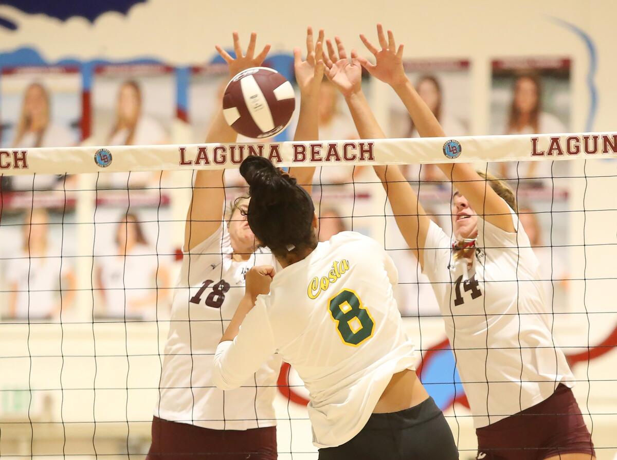 Mira Costa's Savannah Green (8) hits the ball into Laguna Beach's Luisa LoFranco (18) and Piper Naess in the first round of the CIF Southern Section Division 1 playoffs on Thursday.