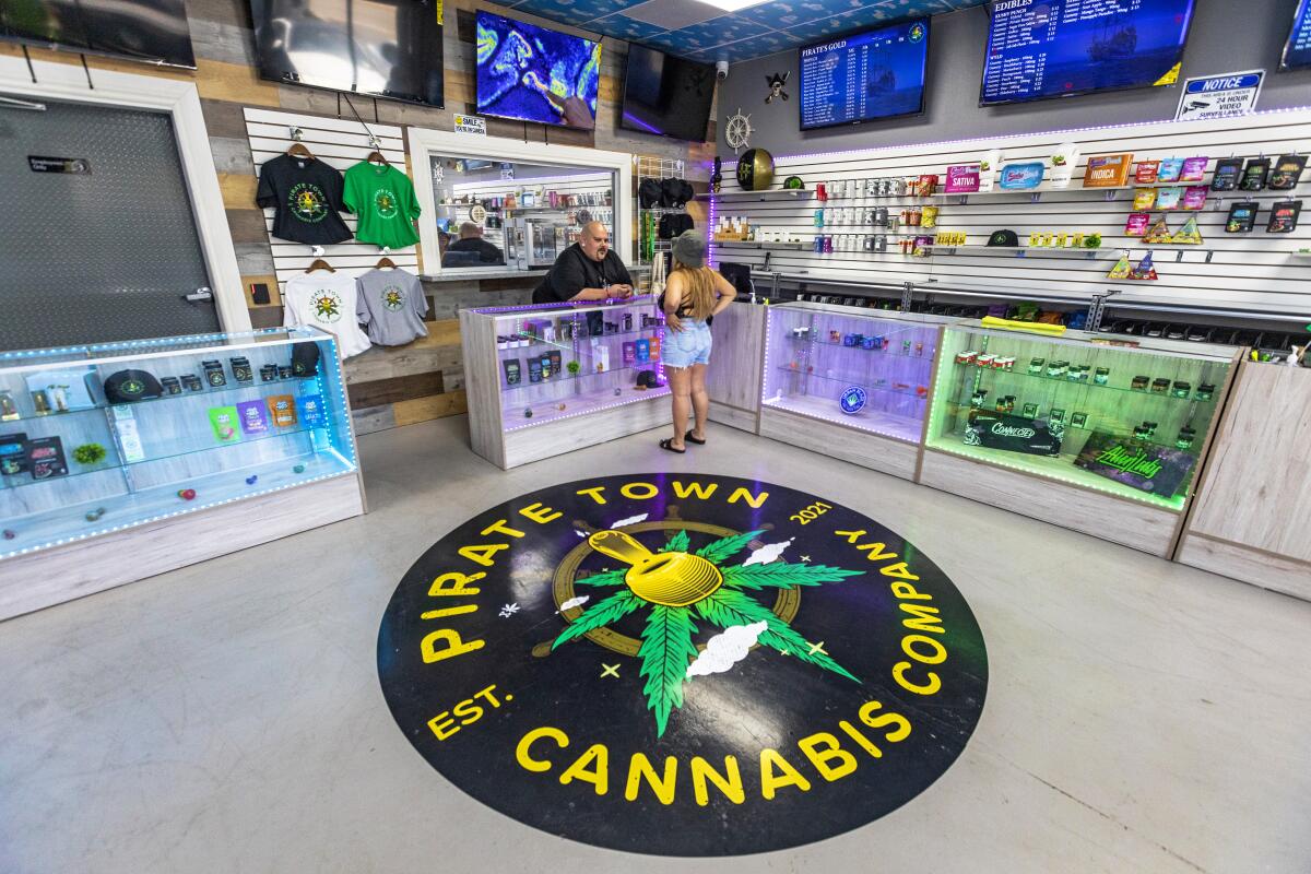 The interior of a San Pedro dispensary with a pirate-themed logo displayed on the floor