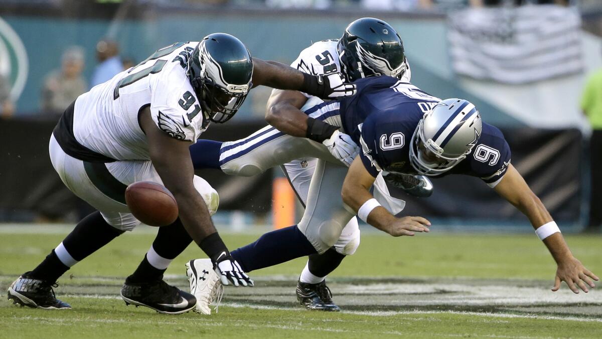 Cowboys quarterback Tony Romo (9) fumbles the football against Eagles defenders Fletcher Cox (91) and Jordan Hicks (58) and would sustain a broken collarbone on the play.
