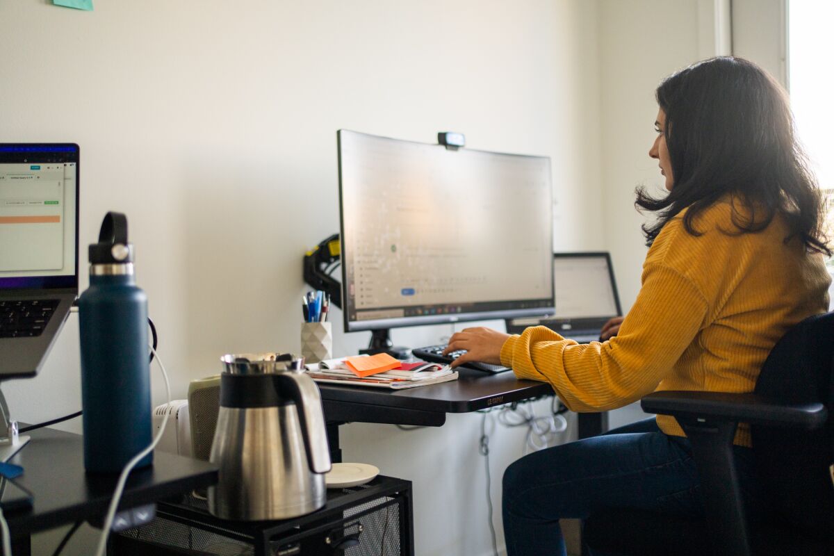 a woman working at a computer at home 