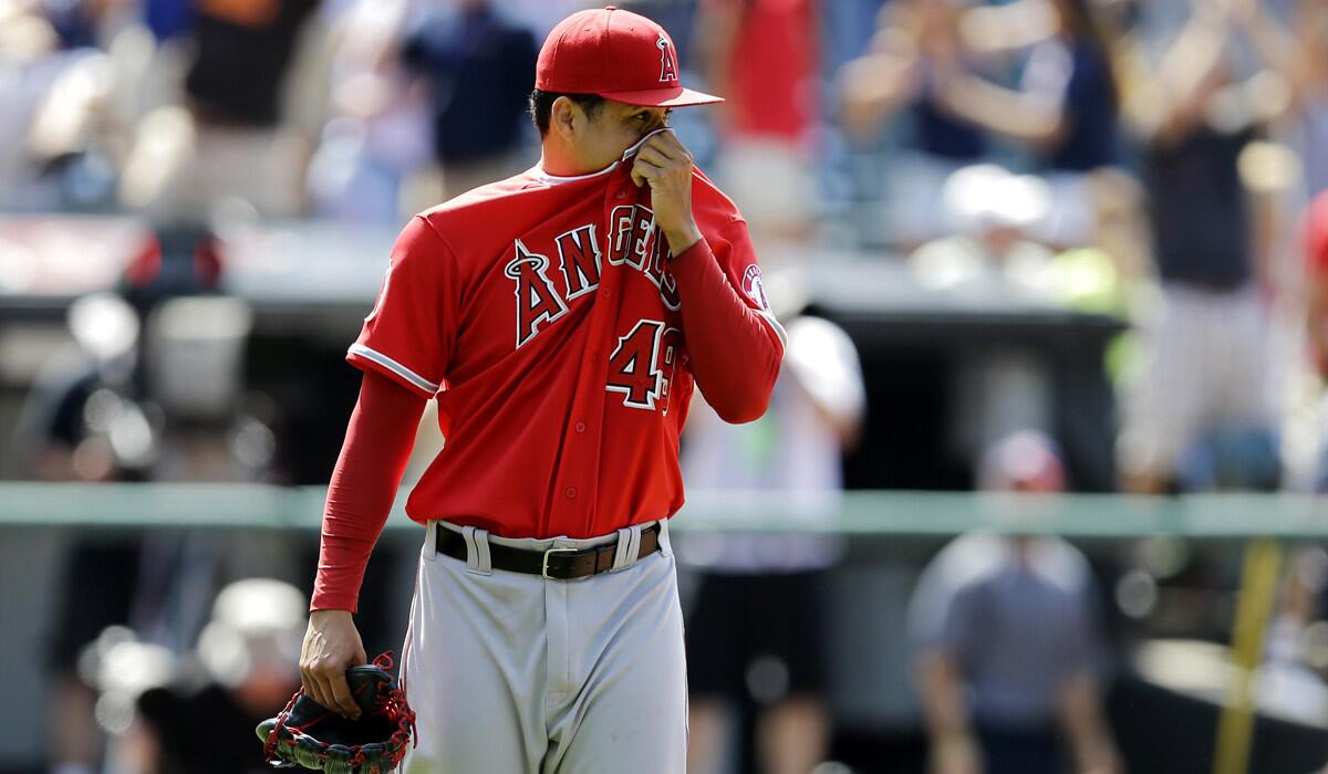 Angels reliever Ernesto Frieri walks off the field after giving up a grand slam to Cleveland's Nick Swisher in the 10th inning Thursday afternoon.