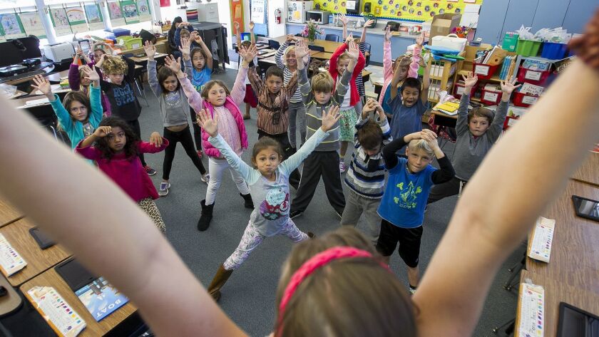 First-graders at Harbor View Elementary School in Corona del Mar follow yoga instruction in 2016. Harbor View is one of seven Newport-Mesa Unified School District campuses scheduled to receive air conditioning this summer.