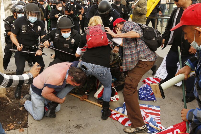 LOS ANGELES, CA - JANUARY 06: Pro-Trump demonstrators fight with anti demonstrators after a pro-trump rally outside Los Angeles City Hall Wednesday, Jan. 6, 2021. Demonstrators, supporting President Donald Trump gathered in various parts of Southern California as Congress debates to affirm President-elect Joe Biden's electoral victory. Downtown City Hall on Wednesday, Jan. 6, 2021 in Los Angeles, CA. (Al Seib / Los Angeles Times)
