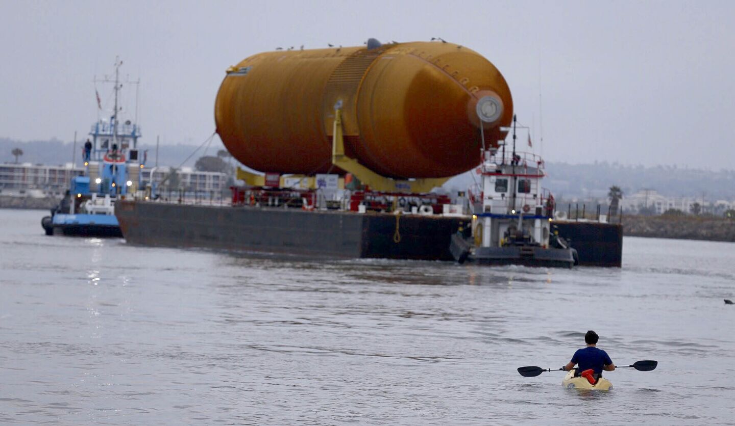 A kayaker watches as the space shuttle external fuel tank ET-94 arrives in Marina del Rey.