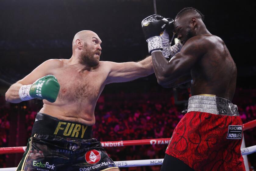 Tyson Fury, of England, hits Deontay Wilder in a heavyweight championship boxing match Saturday, Oct. 9, 2021, in Las Vegas. (AP Photo/Chase Stevens)
