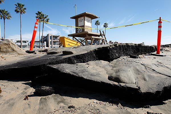 Asphalt is broken up near the Newport Pier, where recent storms, high surf and high tides have eroded the beach.