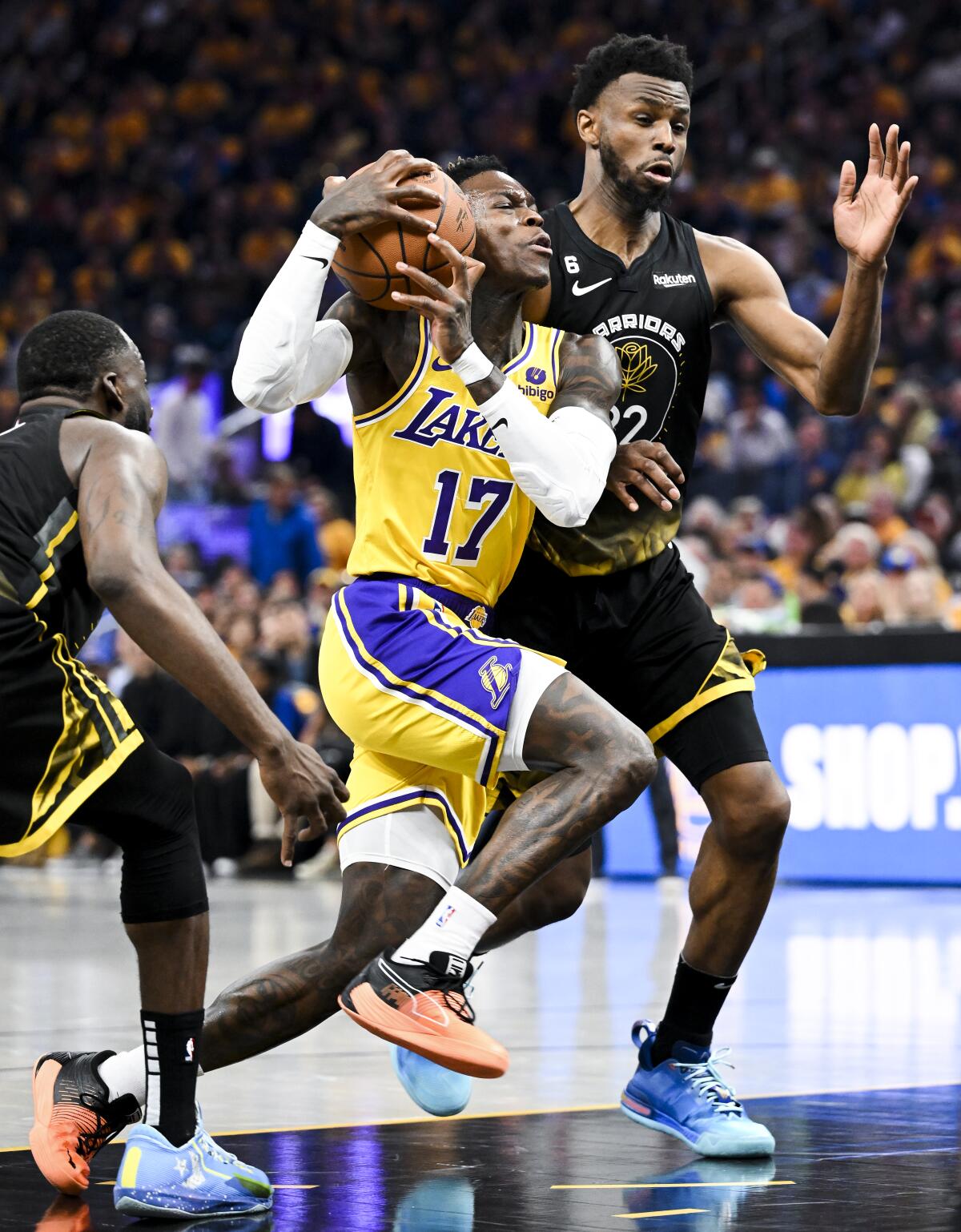 Lakers guard Dennis Schroder drives down the lane against Warriors forwards Draymond Green, left, and Andrew Wiggins.