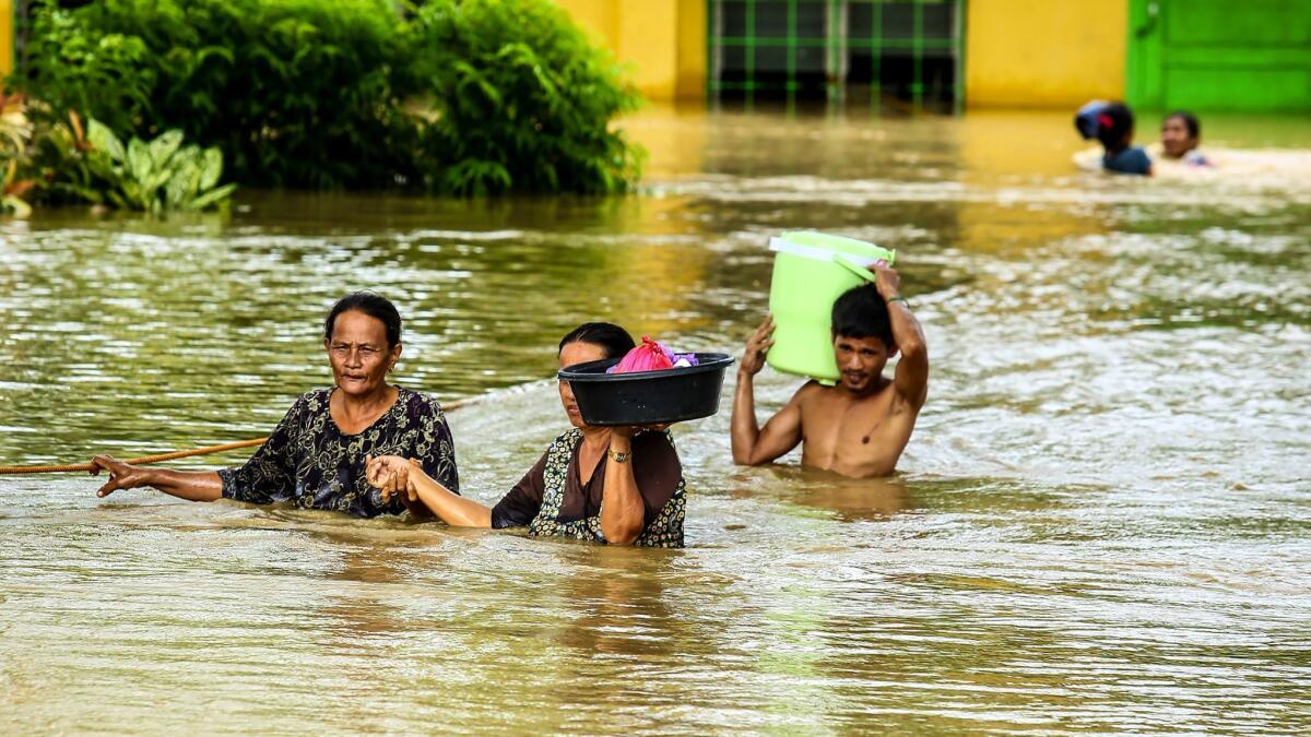 Residents wade through floodwater as they evacuate to a safer place in Kabacan, Cotabato, on the southern island of Mindanao.