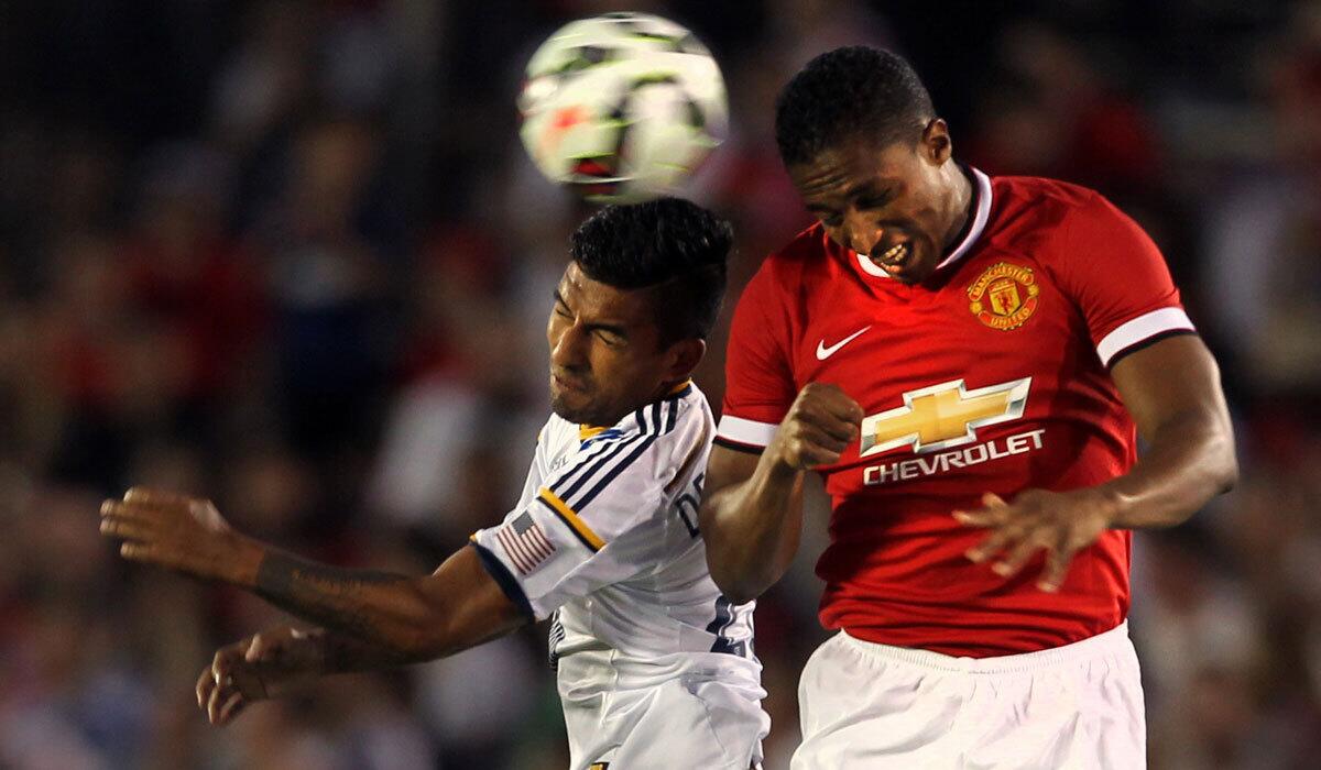 Galaxy's A.J. Delagarza, left, goes for a header against Manchester United's Danny Welbeck at the Rose Bowl in July.
