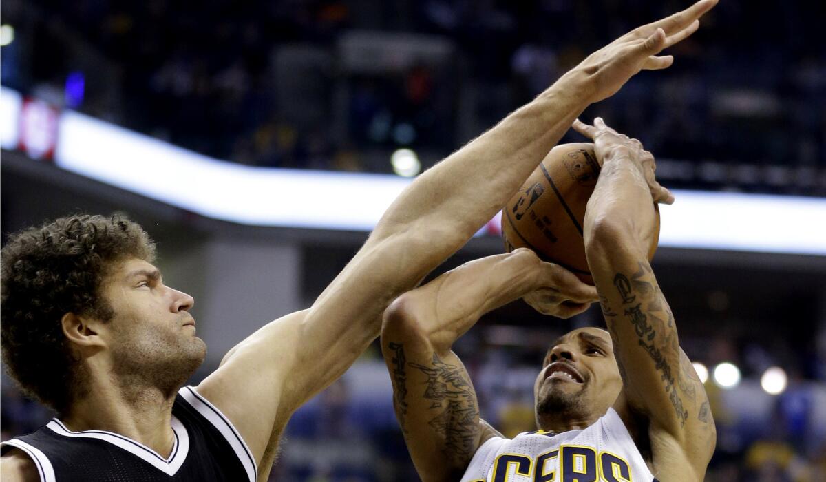 Nets center Brook Lopez blocks a shot by Pacers guard George Hill in the second half Saturday night in Indianapolis.