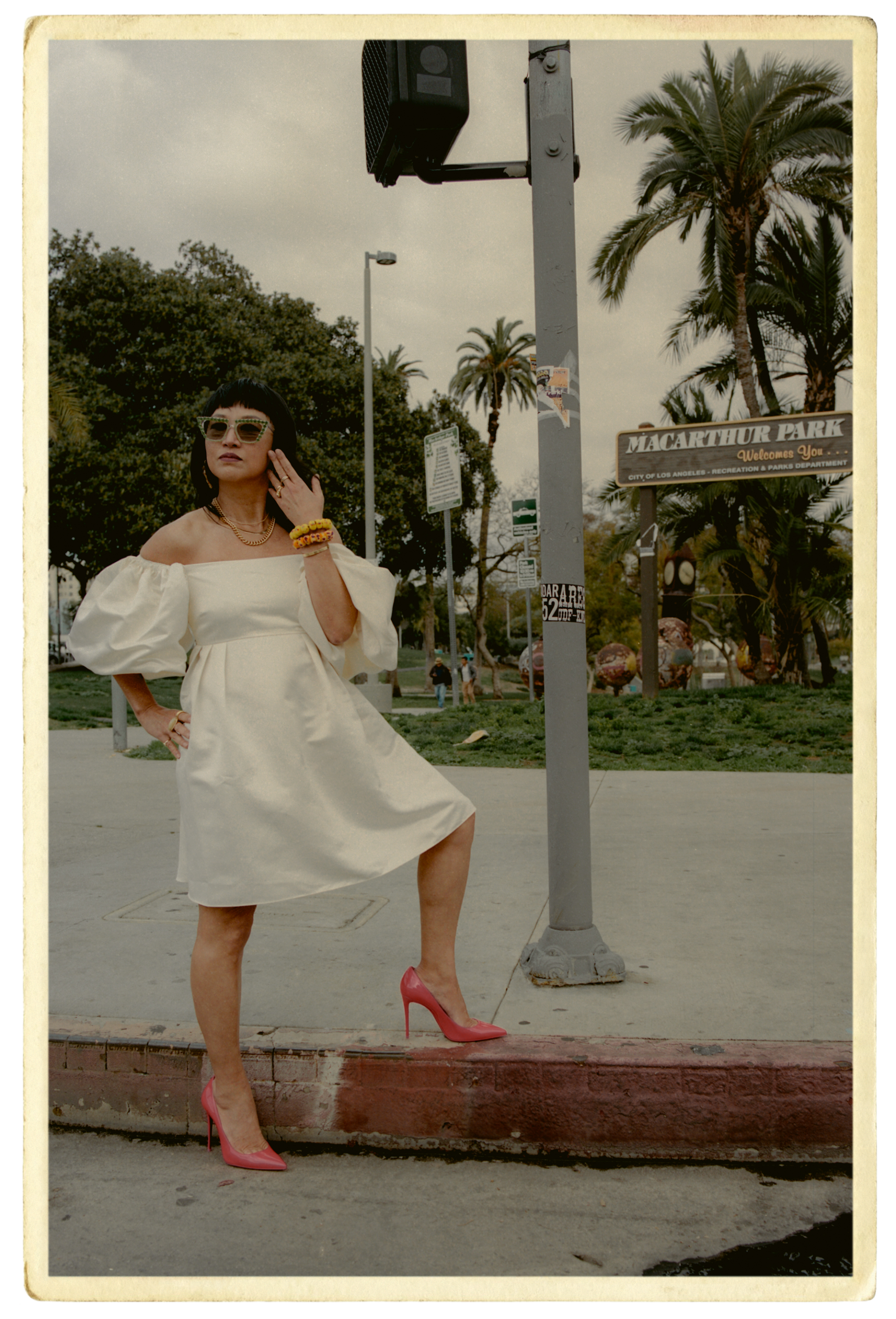 Christine Y. Kim poses in front of MacArthur Park sign
