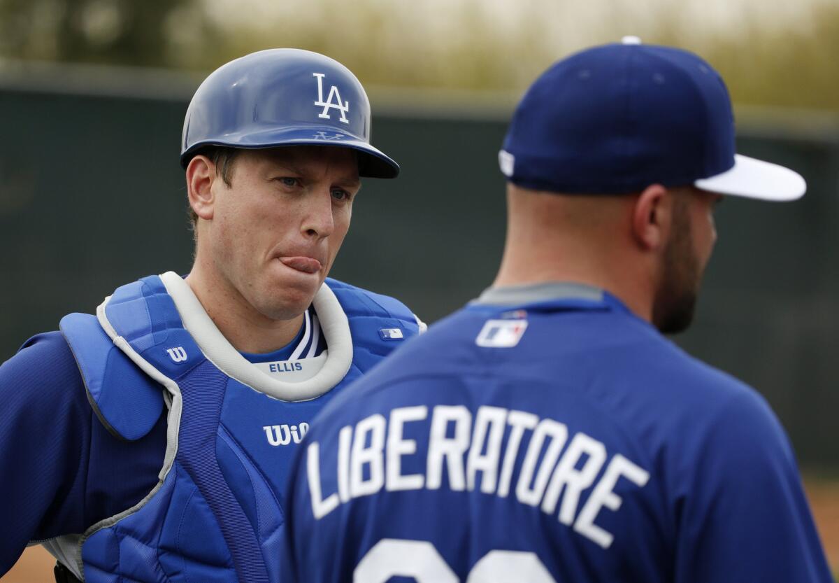 Dodgers catcher A.J. Ellis talks with pitcher Adam Liberatore during a spring training workout on Friday in Phoeinx.