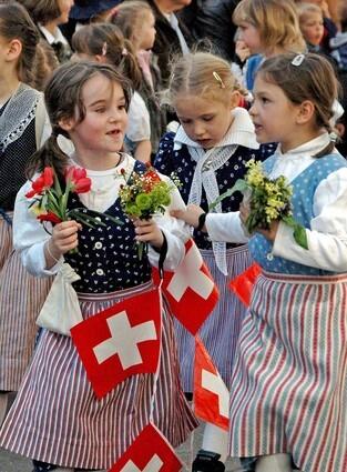 Flower-bearing schoolgirls in traditional dress parade through Zurich as part of the citys annual spring celebration.