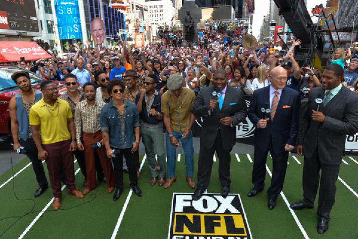Bruno Mars, sixth from left, is with Curt Menefee, from third right, Terry Bradshaw and Michael Strahan in Times Square after it was announced Sunday that Mars will play during the Super Bowl XLVIII halftime show Feb. 2.