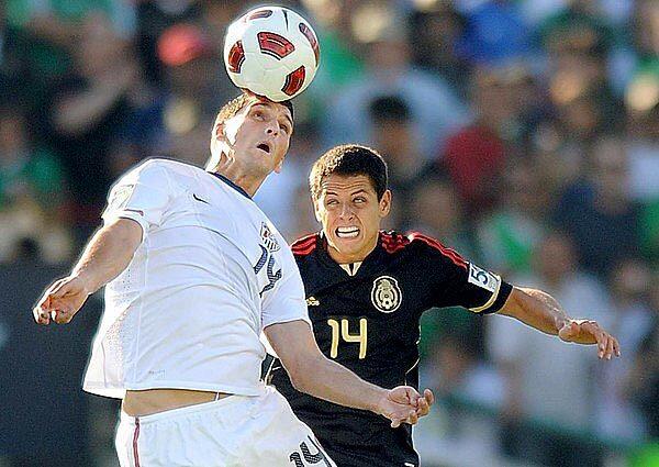 U.S. defender Eric Lichaj heads the ball away from Mexico forward Javier Hernandez in the first half of the Gold Cup final on Saturday evening at the Rose Bowl.