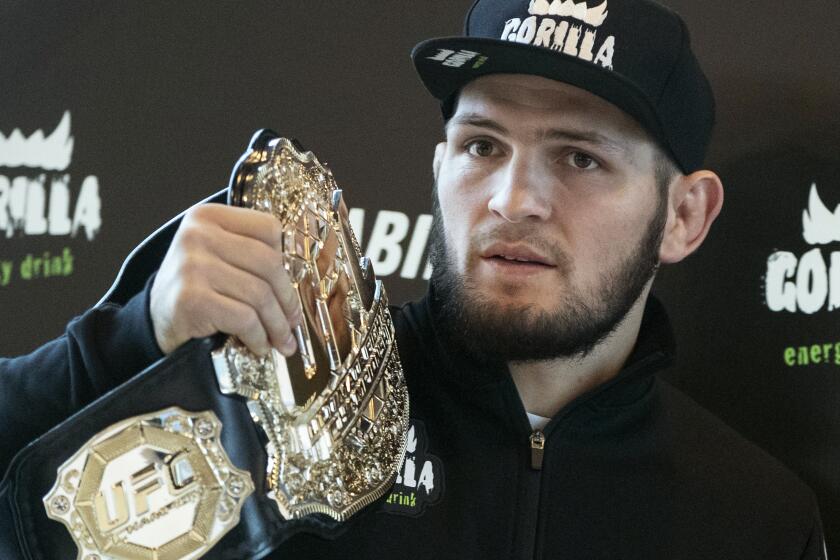 UFC lightweight champion Khabib Nurmagomedov holds the trophy belt during a news conference in Moscow, Russia, Monday, Nov. 26, 2018. The Russian professional mixed martial arts fighter Nurmagomedov, said he can imagine a reconciliation with Conor McGregor after the bitter feud around last month's title fight, but said he would like to fight Floyd Mayweather Jr. (AP Photo/Pavel Golovkin)